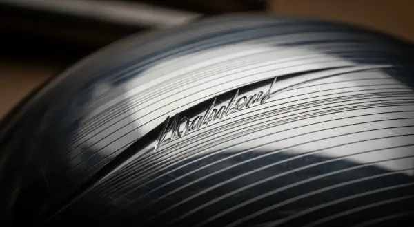Repuxamento e Cinzelamento na Joalheria Artesanal, macro de alta resolução de superfície de prata cinzelada com um sulco diagonal profundo e sombras pretas absolutas em alto contraste