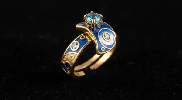 Joias talismãs personalizadas, anel de ouro 18k com design de fases lunares, pedra topázio azul central e detalhes em esmalte cloisonné sobre veludo preto.